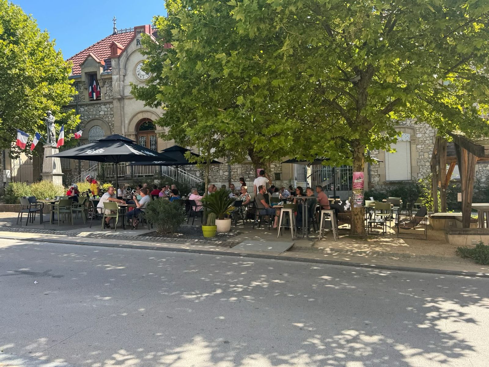 La terrasse ombragée, tables occupées un après-midi.