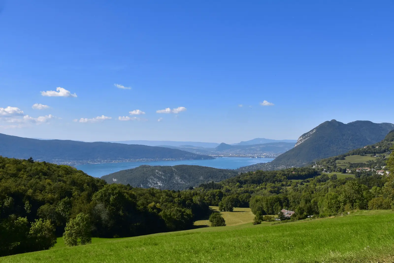 Paysage donnant sur des montagnes et un lac depuis une plaine.